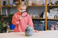 Girl in Pink Long Sleeve Shirt Holding Magnifying Glass