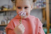 Girl in Pink Hoodie Holding Purple Flower