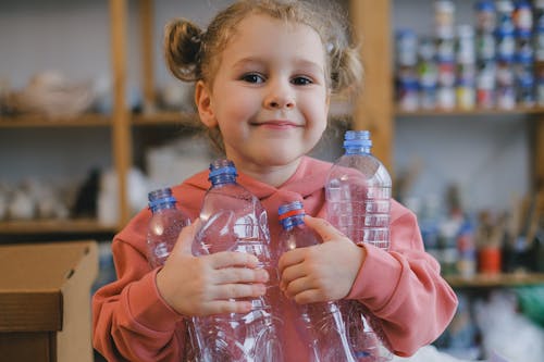 A Smiling Girl Carrying Plastic Bottles