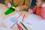 A Child Cutting Colored Paper with Scissors