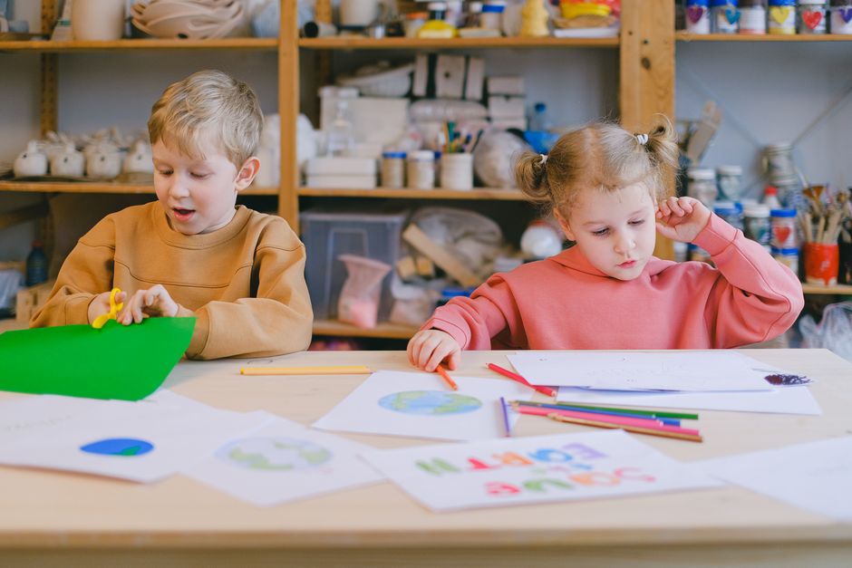 Zwei Kinder beschäftigten sich im Klassenzimmer mit Kunst und Handwerk, wobei der Schwerpunkt auf Kreativität und Lernen lag.