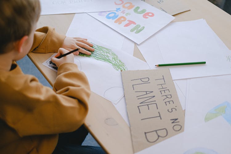 Boy Drawing At A Desk