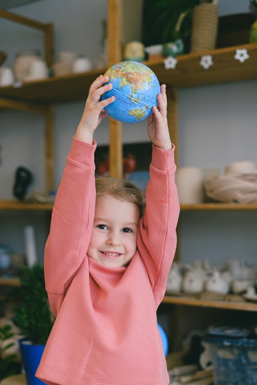 A Little Girl Holding a Globe
