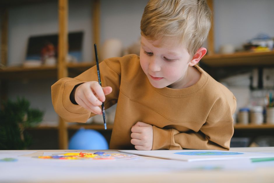 Niño dedicado a la pintura creativa en un estudio de arte interior.