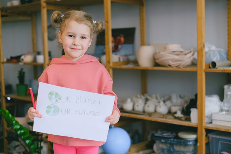 A Little Girl Holding A Placard