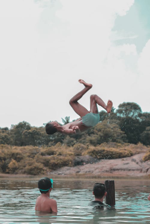 Person Wearing Shorts Back Flipped over Body of Water