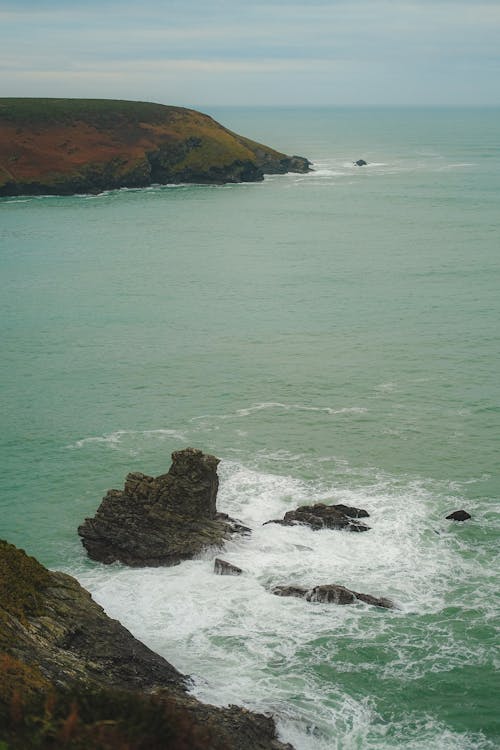 Foto profissional grátis de corpo d'água, espuma do mar, formações rochosas