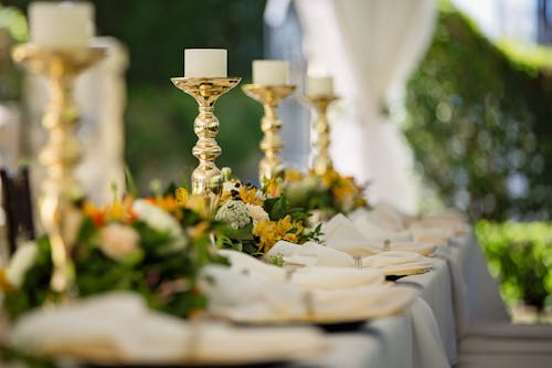 Four White Tealight Candles on Brass-colored Candlesticks