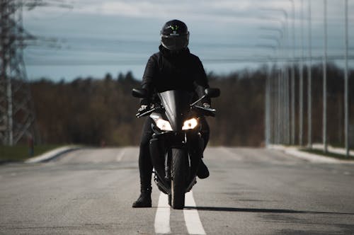 Free Person Wearing an All Black Outfit Riding a Black Motorcycle  Stock Photo