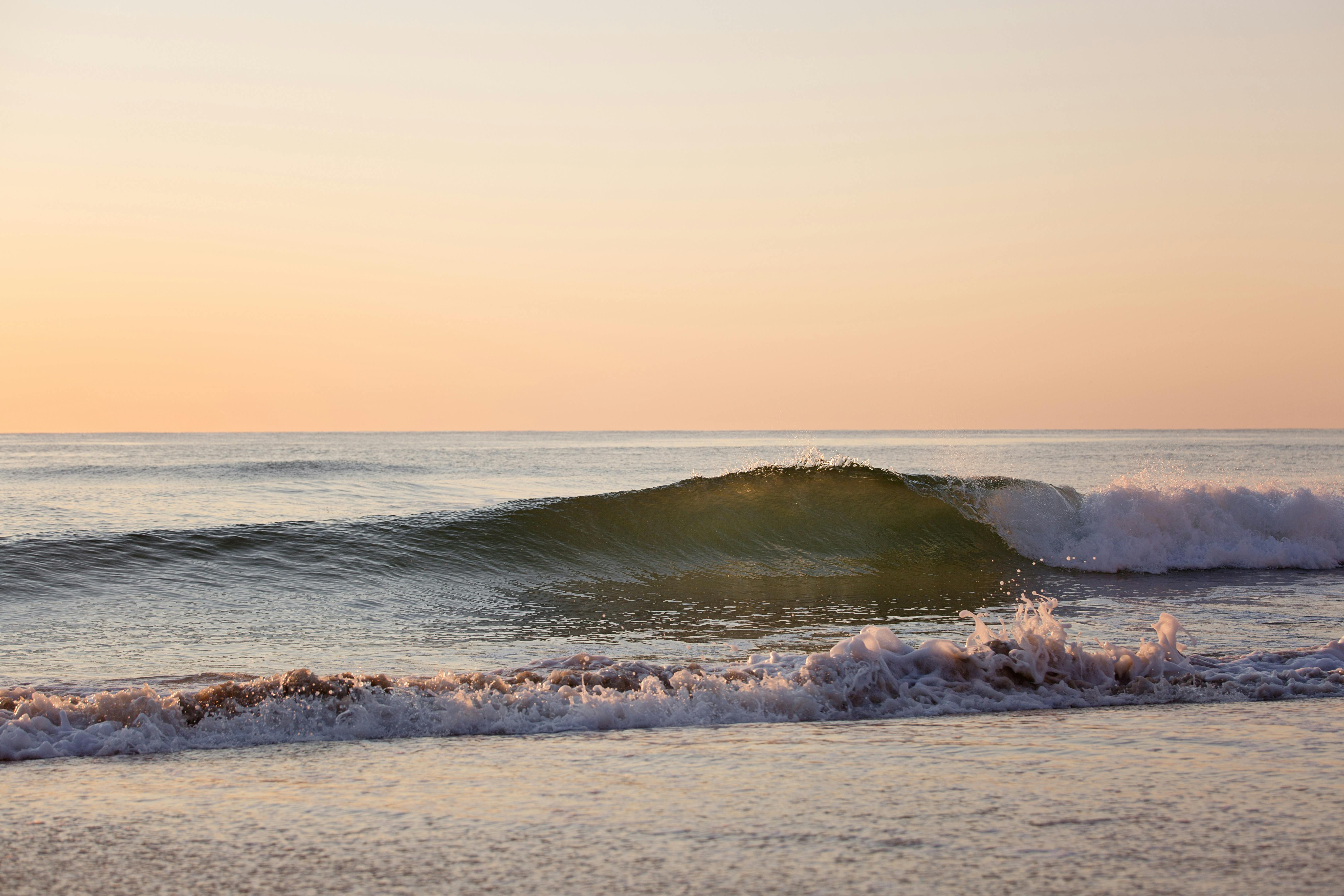 日出时分，平静的海浪在宁静的沙滩上涌向岸边