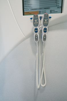 Close-up of handheld controllers on a medical scanner in a healthcare facility, highlighting technology in radiotherapy.