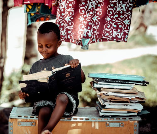 Boy Sitting and Reading Books