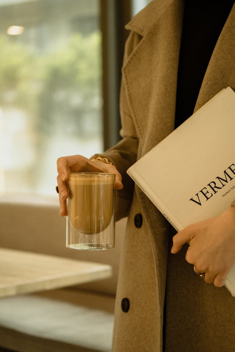 Woman Holding Coffee And Book