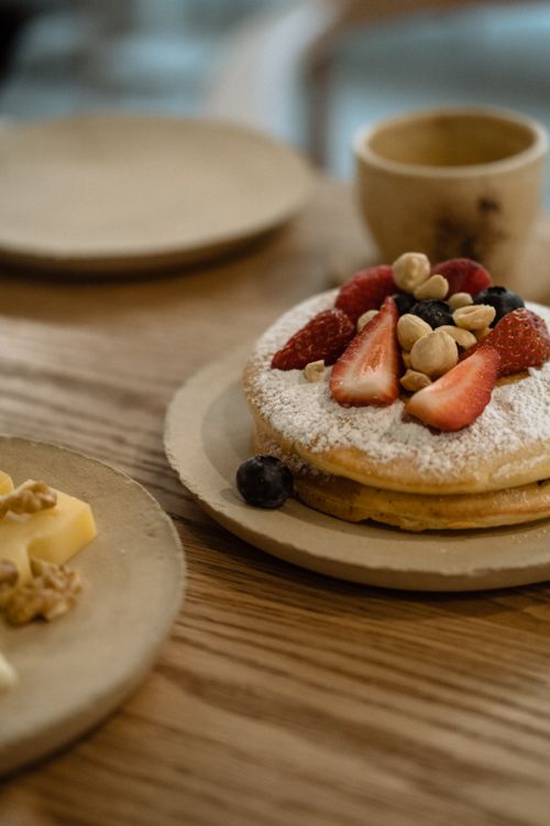 Free Tasty pancakes topped with fresh berries and nuts, perfect for breakfast or brunch. Stock Photo