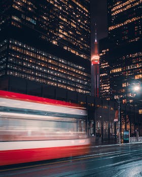 Vibrant night view of Toronto cityscape featuring the iconic CN Tower and illuminated skyscrapers.
