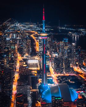 Stunning aerial view of Toronto at night featuring the iconic illuminated CN Tower and city lights.