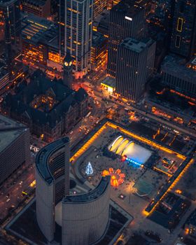 A stunning aerial view of Toronto City Hall and the bustling downtown area illuminated at night.