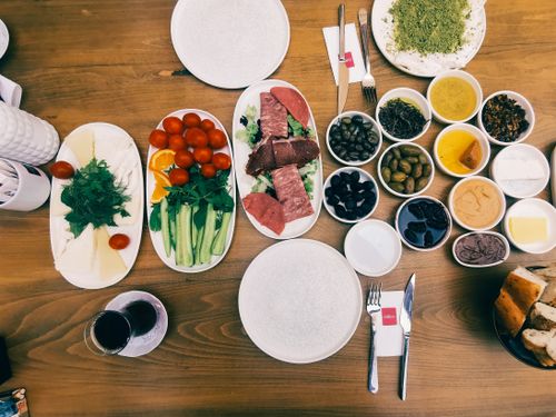 Free Delicious variety of Turkish breakfast dishes and meze, featuring fresh vegetables, cured meats, and olives. Stock Photo