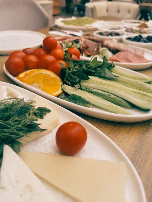Free A vibrant assortment of fresh vegetables, cheeses, and meats artfully arranged on a table. Stock Photo