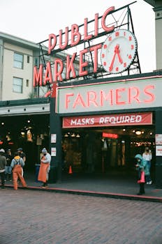 A view of the famous Pike Place Market in Seattle with a 'Masks Required' sign during COVID-19.