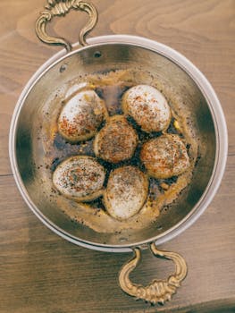 Overhead view of marinated eggs seasoned with spices in a rustic Turkish pot.