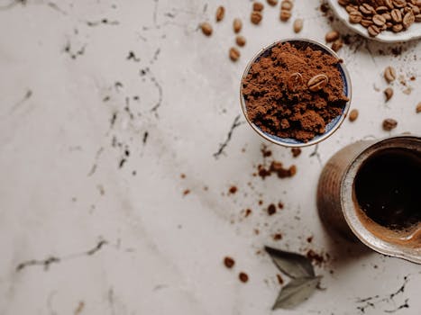 A top-down view of Turkish coffee ingredients featuring coffee beans, powder, and traditional pot.
