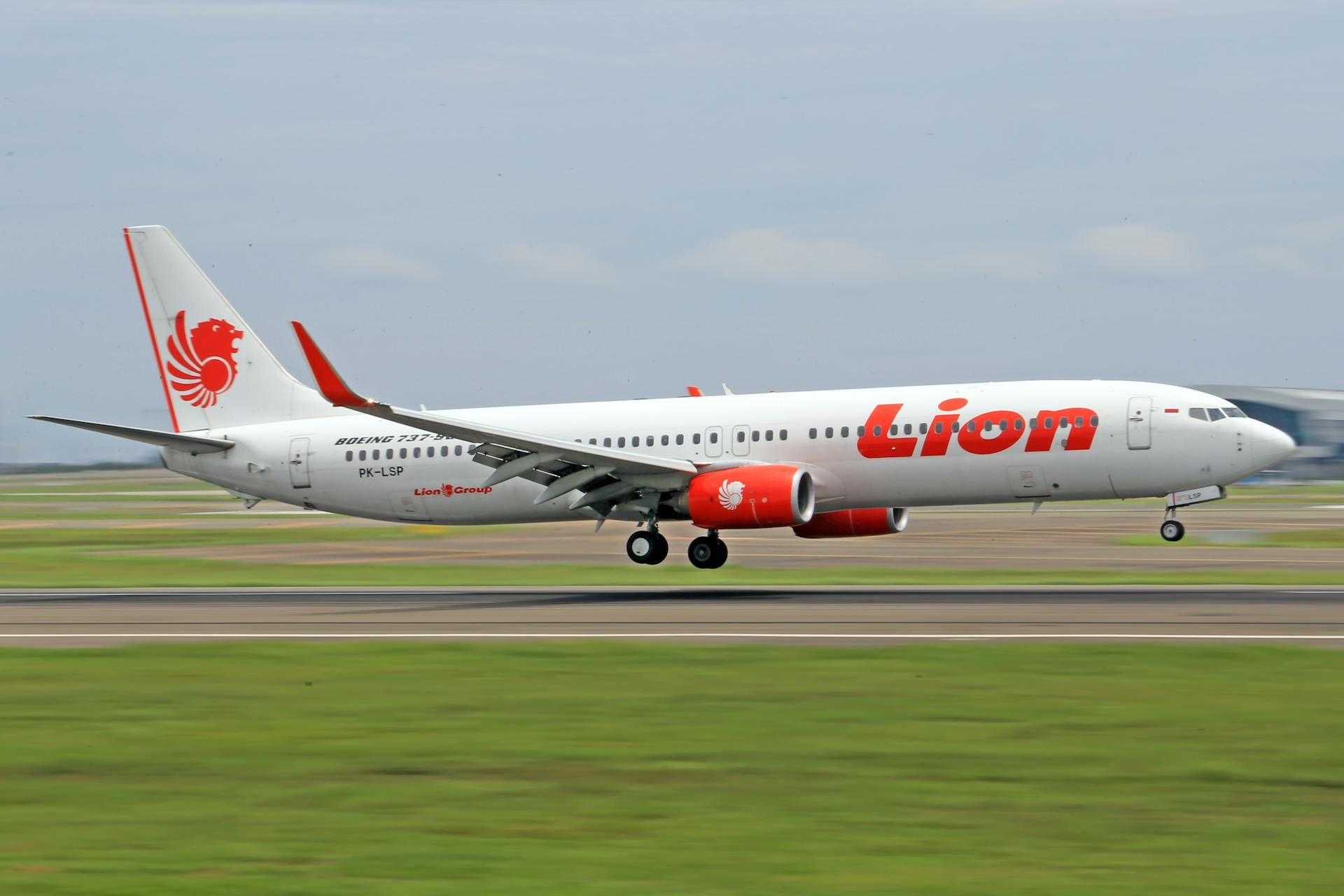 A Lion Air Boeing 737 lands smoothly on an airport runway, showcasing air travel precision.