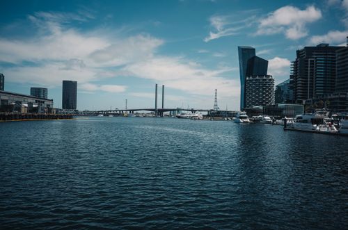 Free Expansive city skyline view featuring modern architecture, a bridge, and boats at a waterfront. Stock Photo