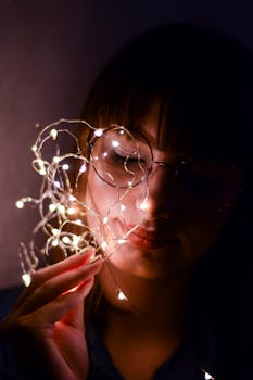 一个女人手持灯串的肖像，营造出喜怒无常又亲密的氛围