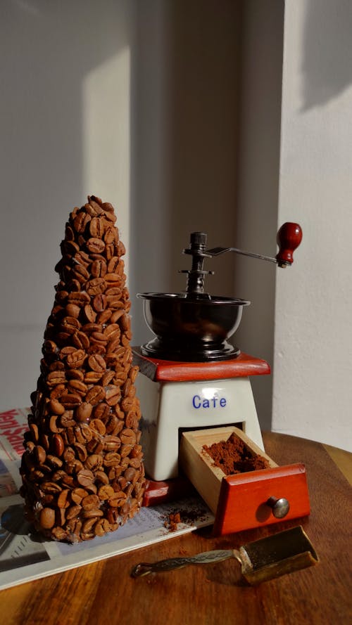 Pile of Coffee Beans and a Coffee Grinder