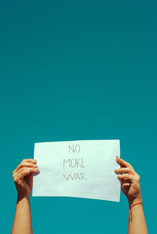 Person Holding Paper with No More War Sign