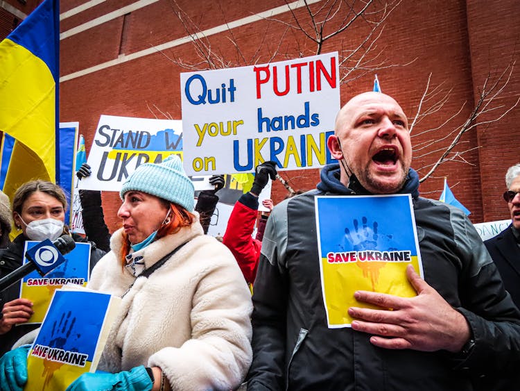 People Holding Anti-War Signs And Protesting In The Street