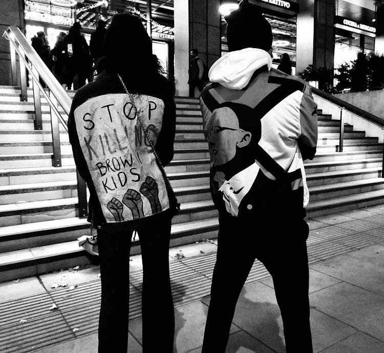 Backs Of Men In Hoodies With Protesting Slogans