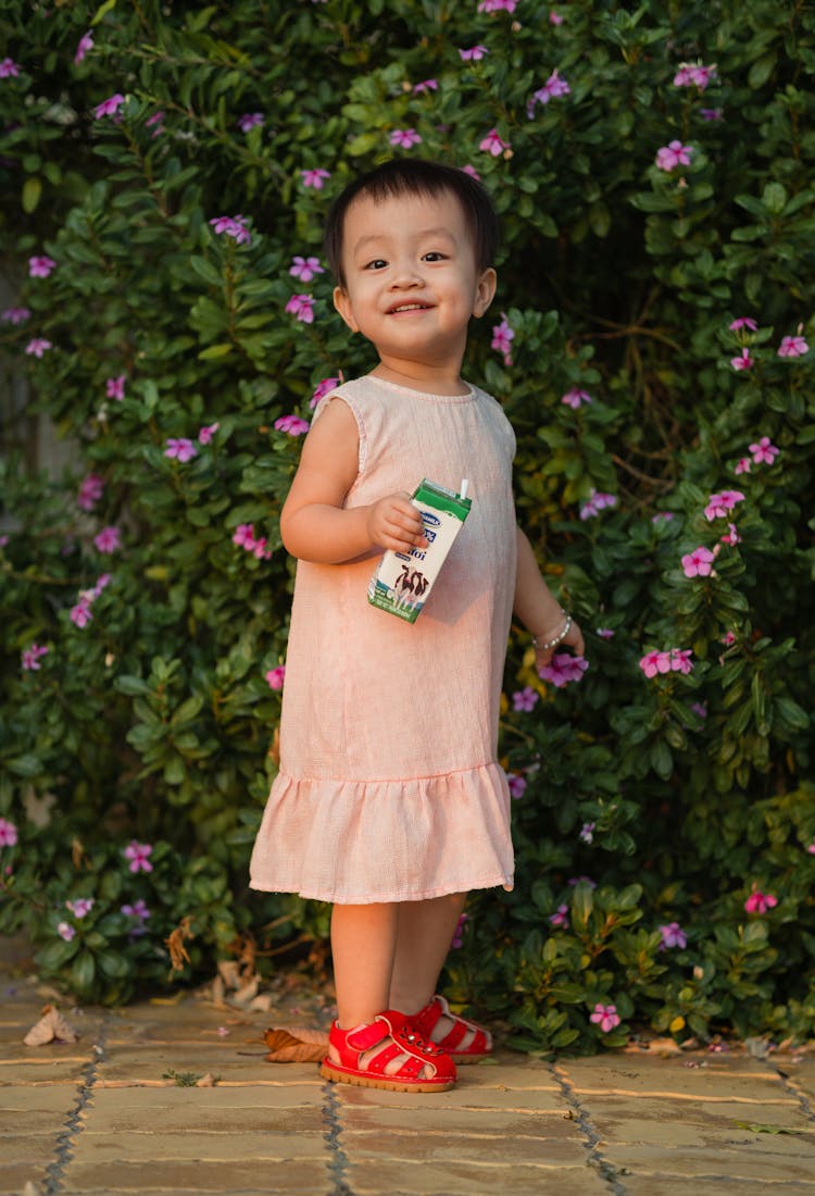 Little Girl Holding Cartoon Of Milk