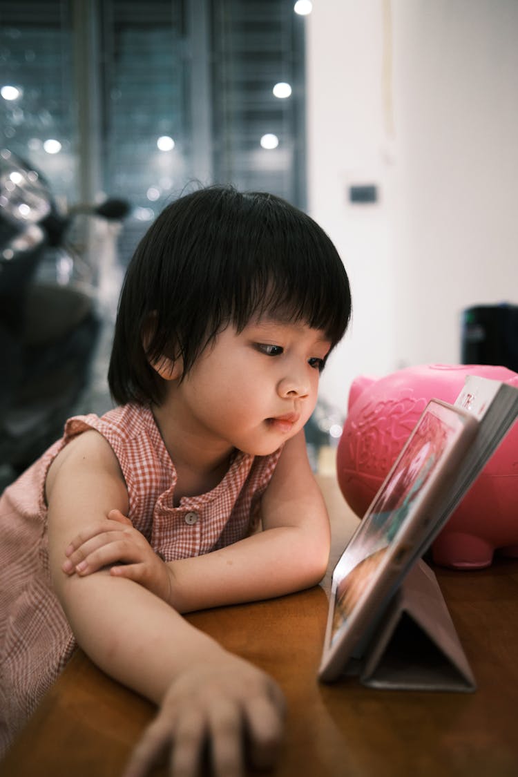 Little Girl Looking At A Photo 