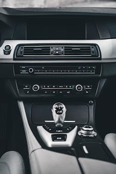 Close-up of a luxury car interior featuring the gear shift and dashboard controls.
