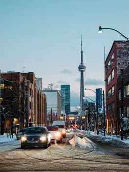 Winter cityscape of Toronto featuring the CN Tower and urban street traffic.