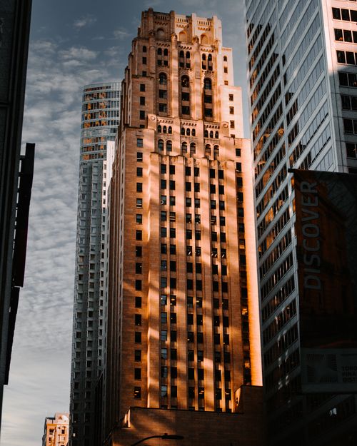 Free A striking cityscape featuring historic high-rise buildings bathed in dramatic evening light. Stock Photo