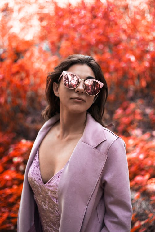 Женщина в розовом пиджаке и солнцезащитных очках «кошачий глаз»