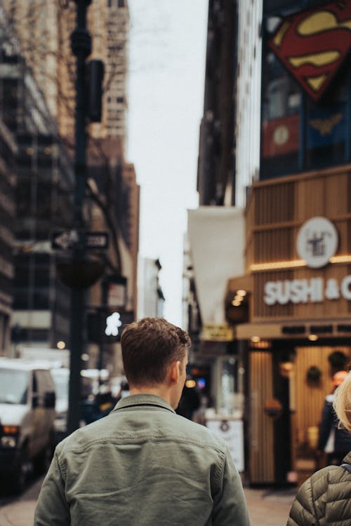 Free Back View of a Man Walking on the Street Stock Photo
