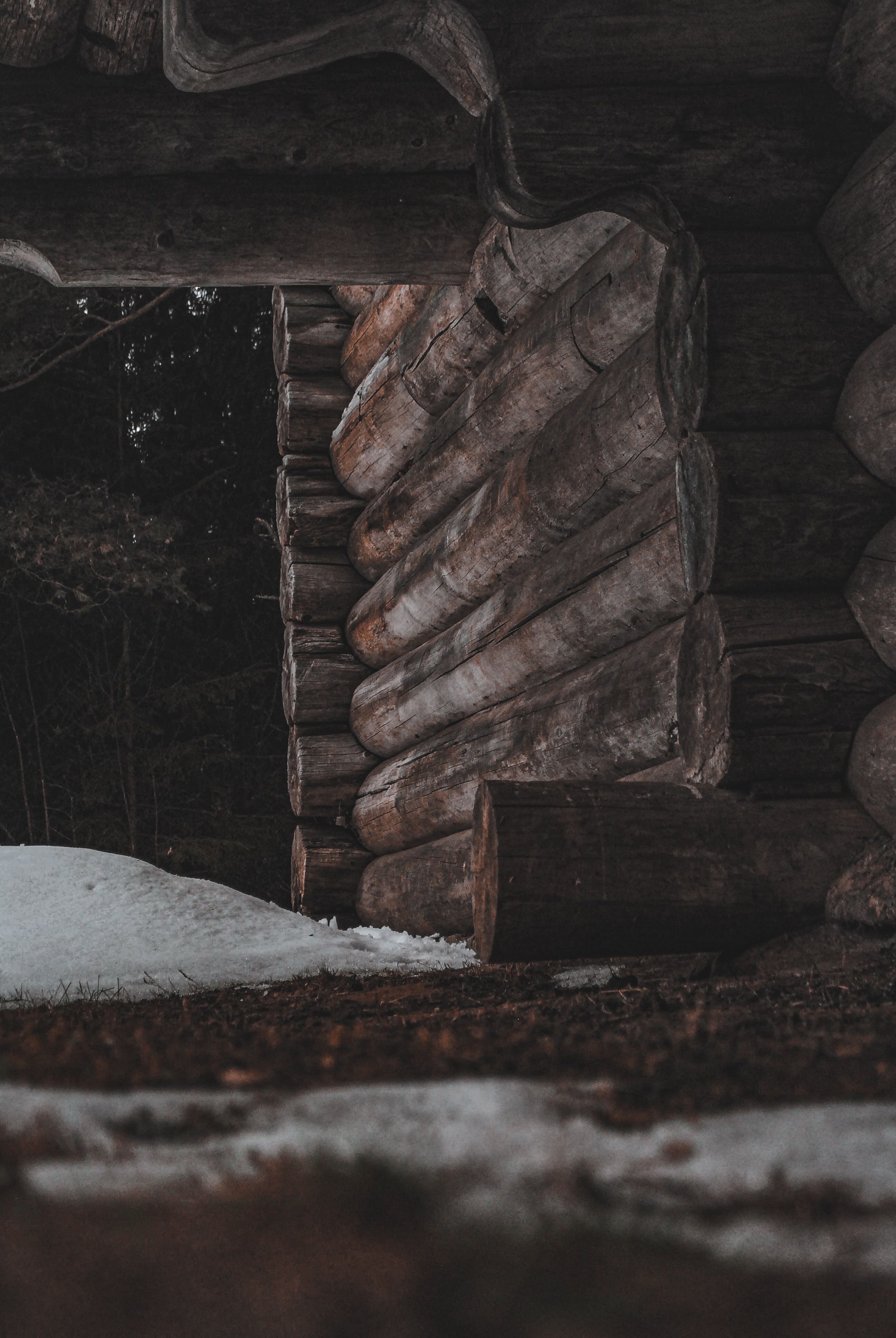 A rustic log cabin in a snowy forest setting, showcasing a serene winter landscape.