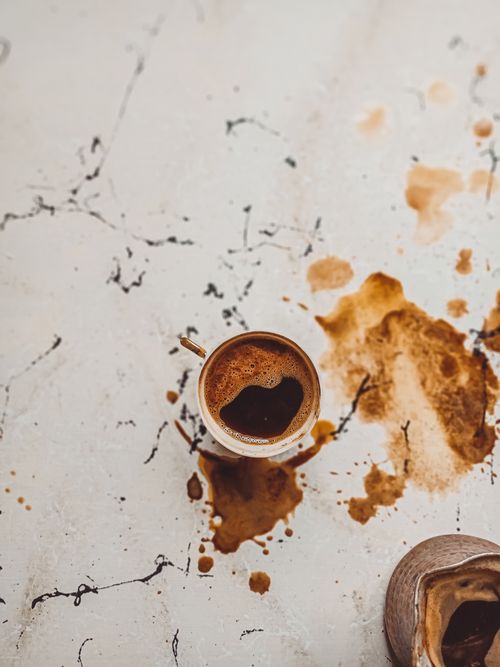Free A top view of a Turkish coffee cup with spills on a rustic marble surface. Stock Photo