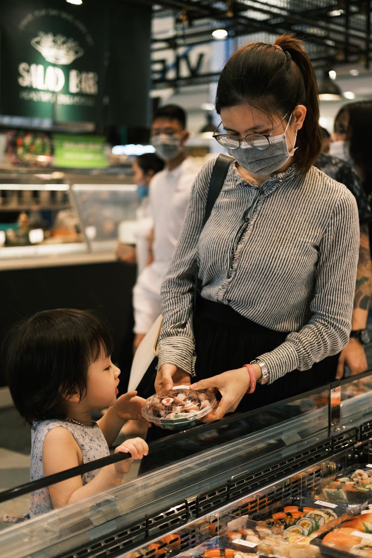 Mother And Child Buying Sushi