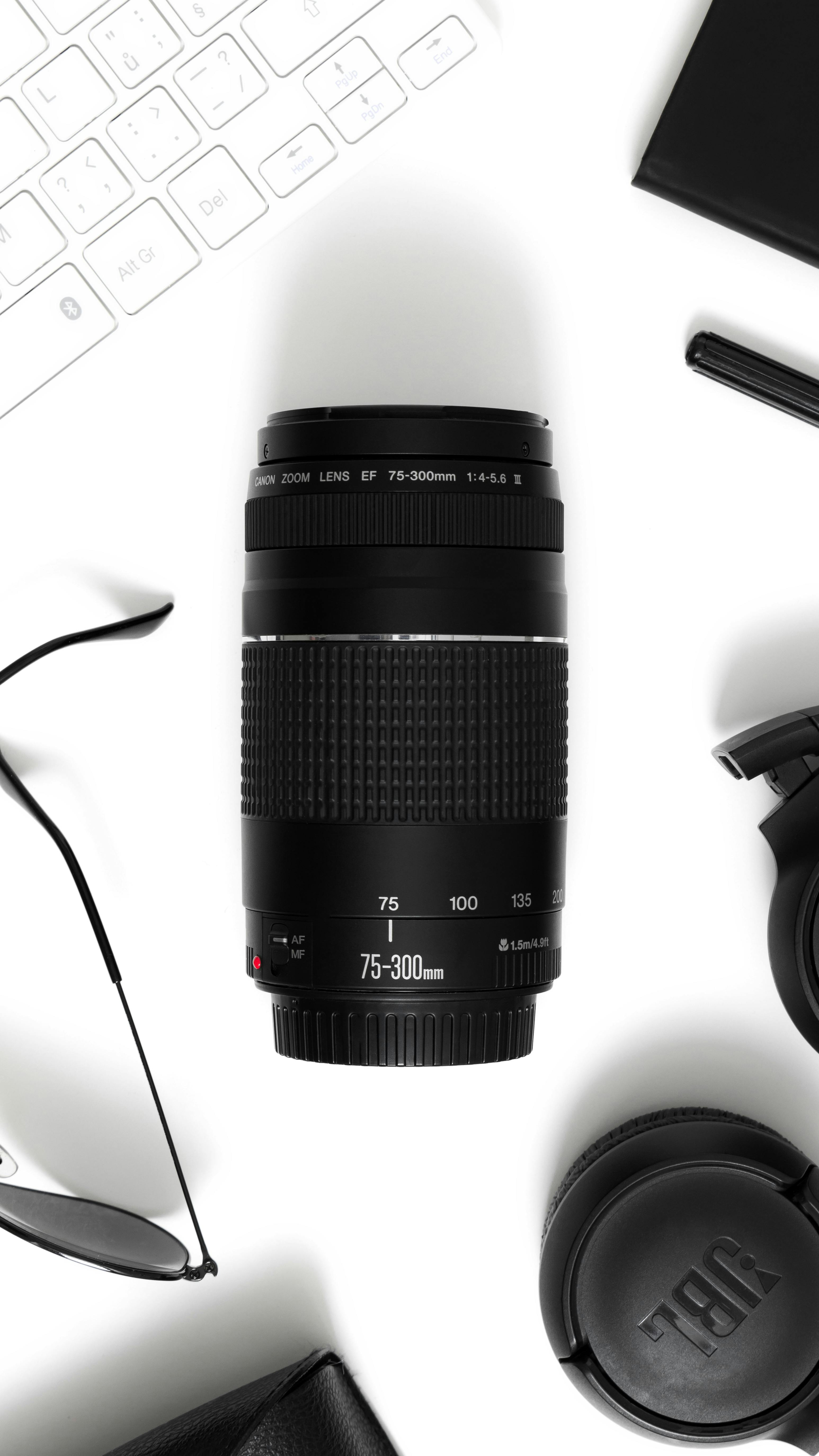 Close-up of camera lens and accessories, shot in a flatlay style.