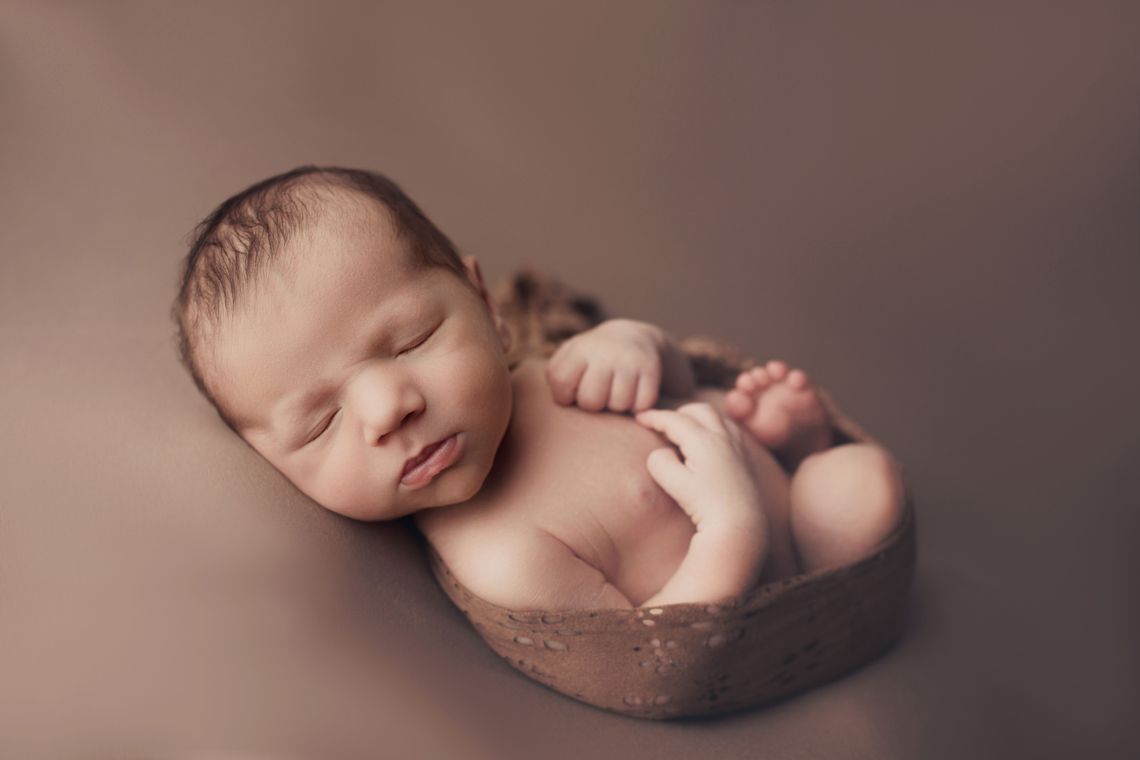 Newborn baby sleeping peacefully in a soft basket