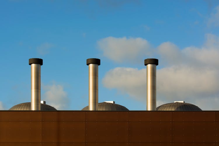 An Industrial Gray Chimney Under Blue Skies