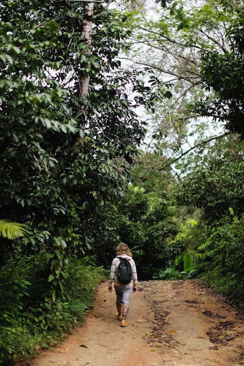 A Woman Walking on Dirt Road