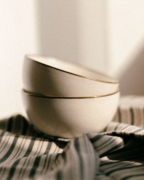 Free Aesthetic still life of stacked ceramic bowls on draped fabric with natural lighting. Stock Photo