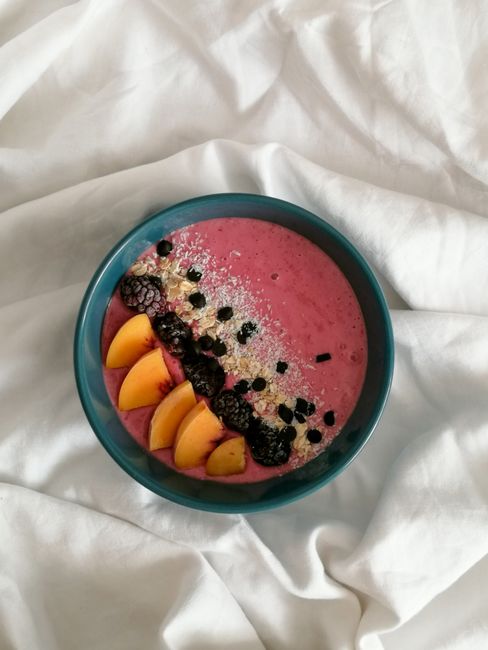 Colorful smoothie bowl with fresh peaches and berries, perfect for a healthy breakfast.