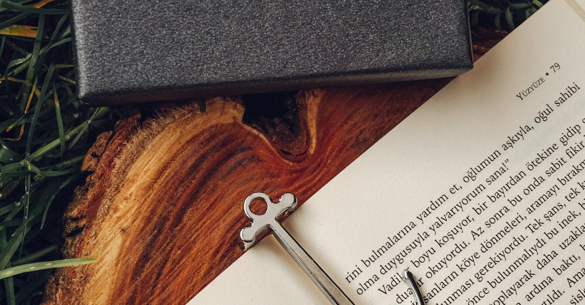 Stylish open book with an anchor bookmark and Moart box on grass, captured outdoors.